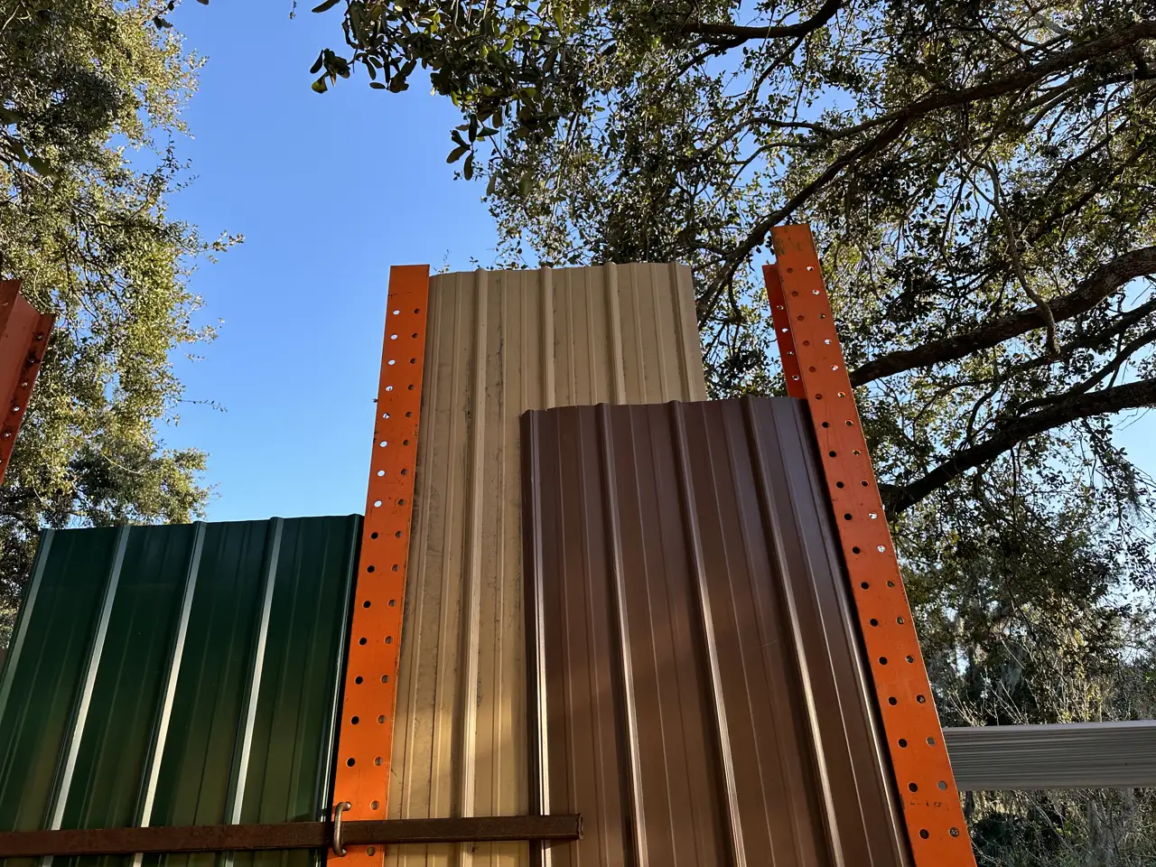 Green, tan and brown Tuff Rib metal roof panels on the rack at FL Sheet Metal